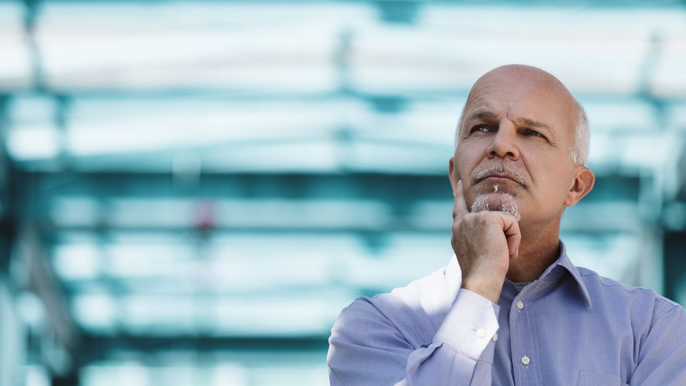 Business man with his hand in his chin contemplating a decision